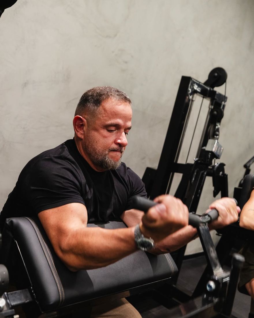 Aluno mais experiente treinando em aparelho na Silva Gym