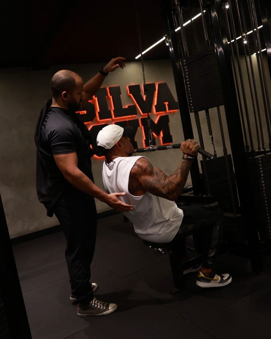 Professor acompanhando a execução de um aluno na Silva Gym